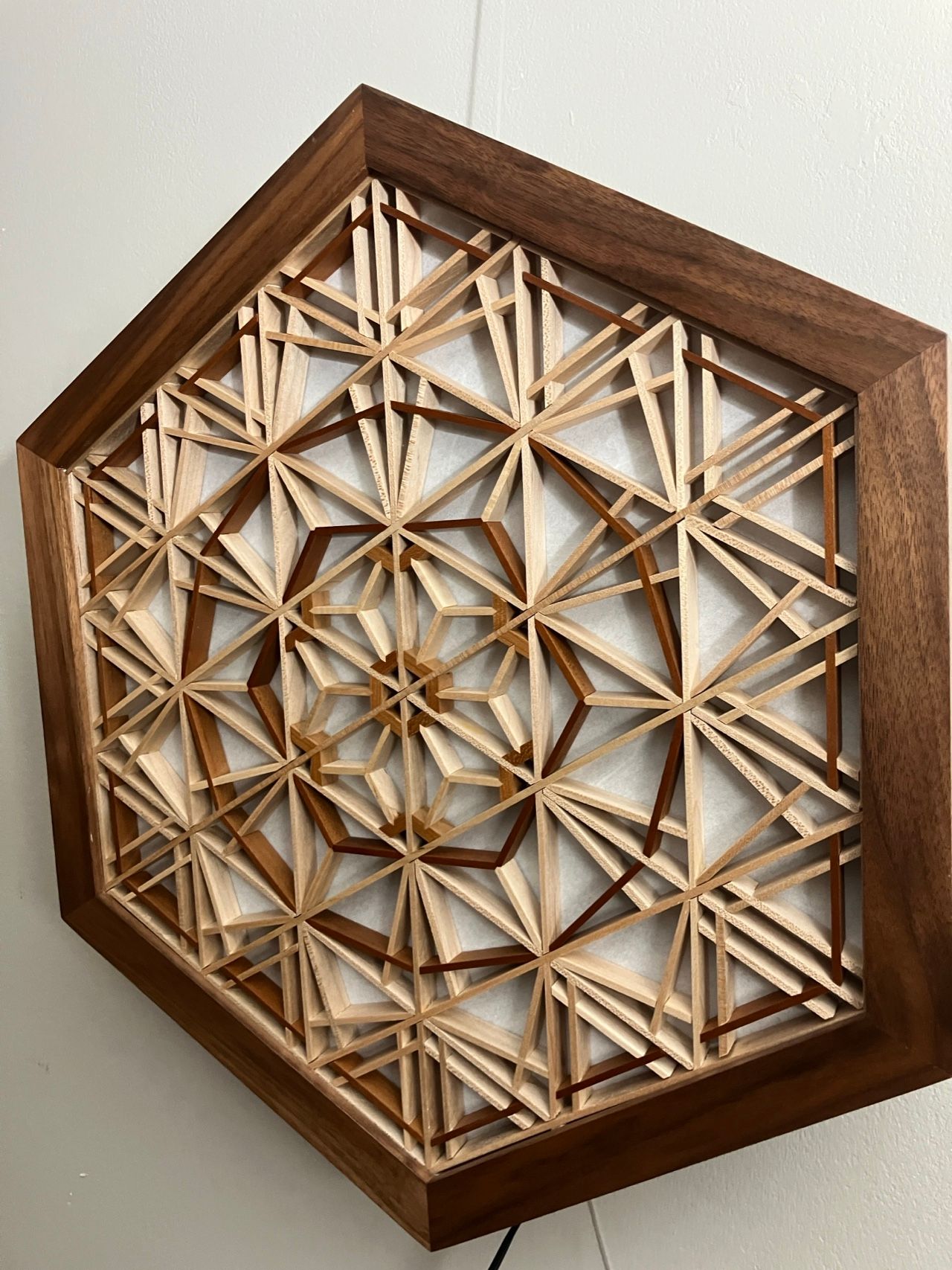 Asa-no-ha table lamp, lit, on a light wall